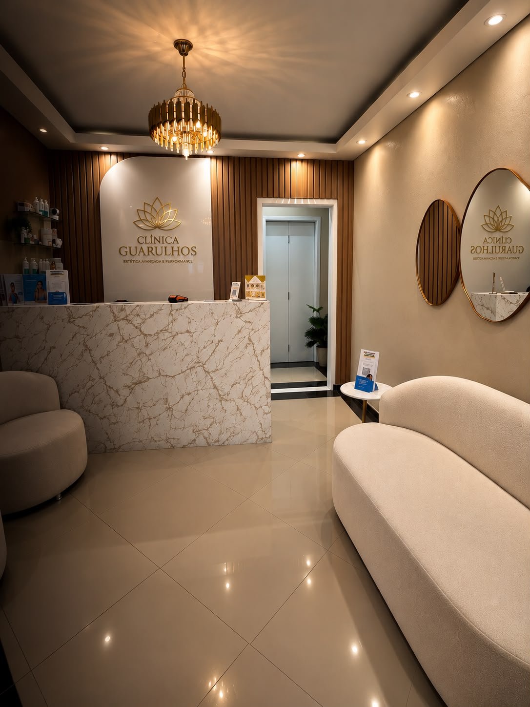 Recepção da clínica com balcão de mármore e poltronas creme